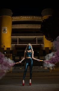 woman standing in front of Stadio Comunale Arechi building while holding purple powder spray thumbnail