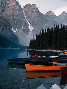 photo of assorted-color canoe on body of water at daytime thumbnail