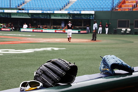 selective focus photo of two blue and black leather baseball mitts thumbnail
