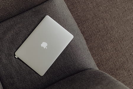 Close up view of closed laptop lying on grey armchair thumbnail
