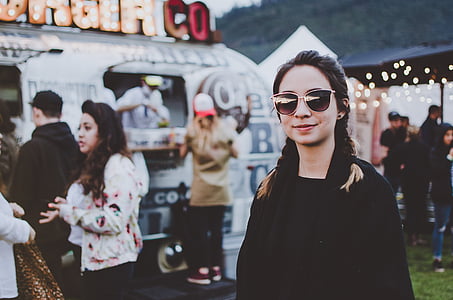 woman in black shirt wearing sunglasses standing near food cart thumbnail
