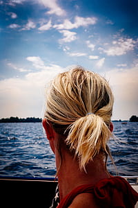 Person's Blonde Hair Looking at Body of Water thumbnail