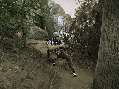 man sitting on ground taking photo thumbnail