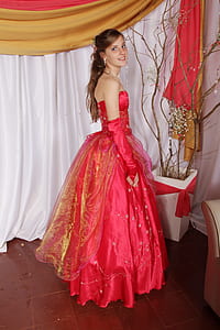 woman wearing red tube dress beside black twigs thumbnail