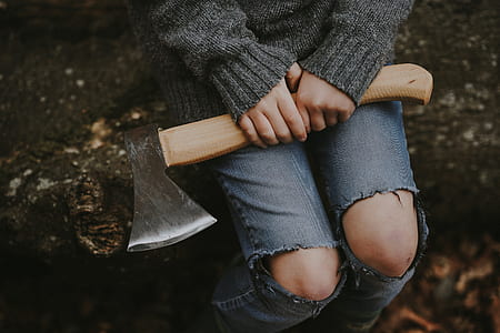 person holding brown wooden handle axe thumbnail
