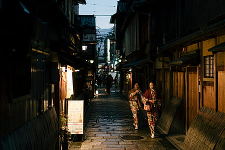 two women walking near houses thumbnail