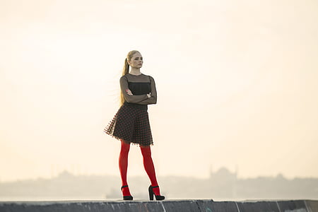 woman standing on concrete pathway during daytime thumbnail