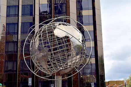 gray metal globe structure near blue building thumbnail