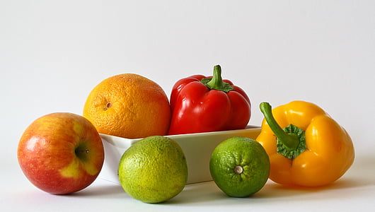 two bell peppers and four fruits on white surface thumbnail