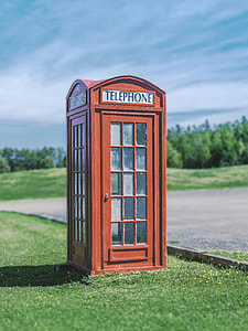 brown telephone booth in the green field thumbnail