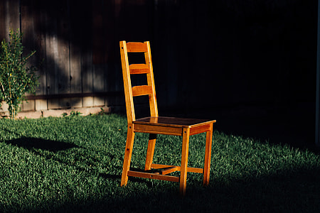 brown wooden armless chair on green grass at night time thumbnail