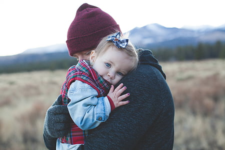 shallow focus photo of person carrying baby thumbnail