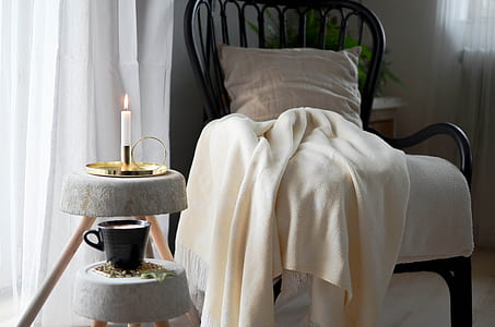 white candle stick near black ceramic mug thumbnail