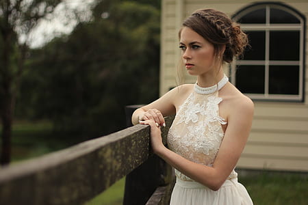 woman wearing halter-neck dress leaning on fence thumbnail