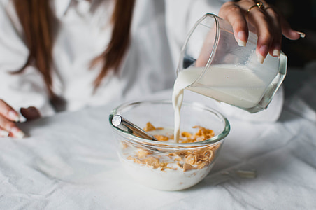 woman holding a drinking glass filled with milk thumbnail