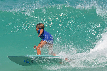boy surfing on waves during daytime thumbnail