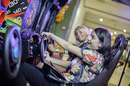 woman sitting on racing arcade machine thumbnail