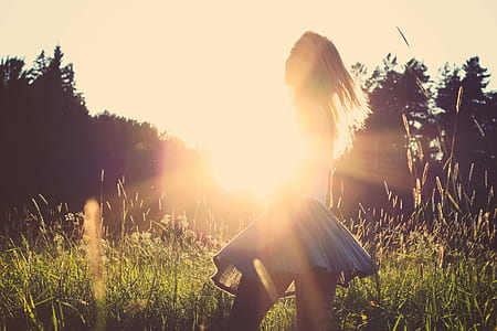 woman wearing gray mini skirt standing beside tall grasses thumbnail