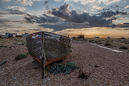 Wide angle landscape shot of an old fishing boat on the beach at sunset in Dungeness in Kent, England. Image captured with a Canon DSLR thumbnail