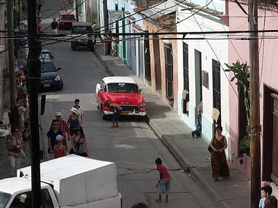 red and white Chevrolet Bel Air parked at street near concrete buildings during daytime thumbnail