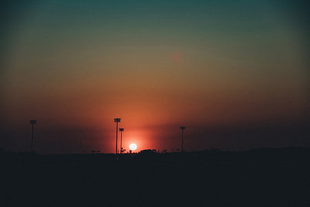silhouette photo of post and tree at golden hour thumbnail