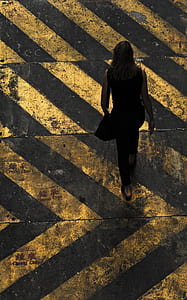 aerial view photography of woman walking on pedestrian lane thumbnail