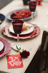 Fancy dinner with seafood pasta, crayfish and red wine by the table decorated with roses thumbnail