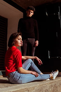 woman sitting on floor beside man standing thumbnail