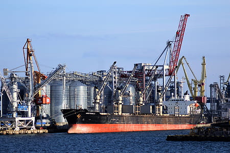 red and black ship docked beside the factory thumbnail