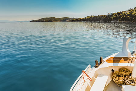white and brown boat on body of water during daytime thumbnail