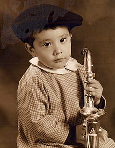 boy holding trumpet while sitting thumbnail