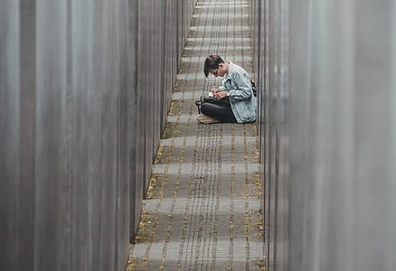 man sitting on floor while writing thumbnail