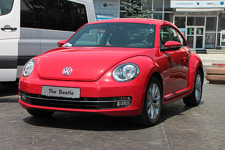 red Volkswagen New Beetle coupe parked next to white vehicle at daytime thumbnail