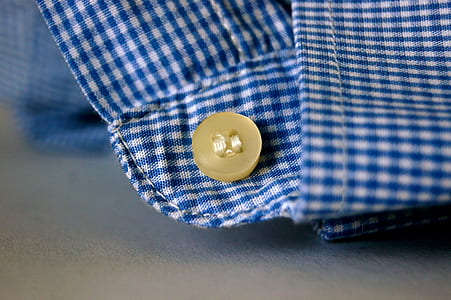 brown button on blue and white plaid textile photo thumbnail