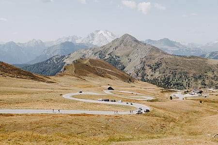 curve concrete road near brown grass field thumbnail
