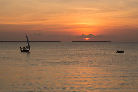 sailing boat on body of water during sunset thumbnail