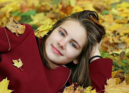 woman laying in yellow leaf covered field thumbnail