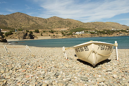 white boat on gray concrete rocks thumbnail