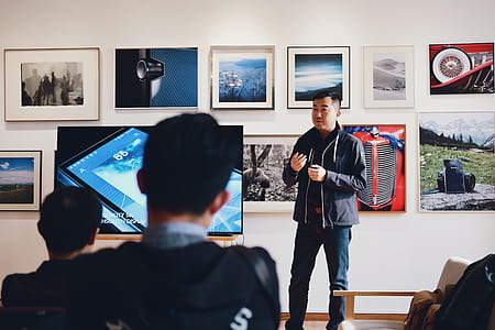 Man Beside Flat Screen Television With Photos Background thumbnail