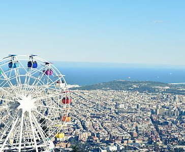 ferris wheel near city buildings under blue sky thumbnail
