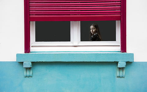 girl inside the house looking at the window during daytime thumbnail
