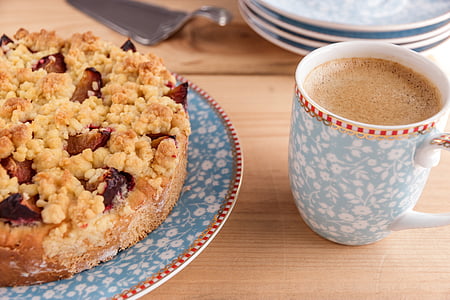 coffee in white and blue mug and bread on saucer thumbnail