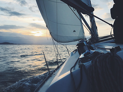 white boat on ocean under white clouds thumbnail