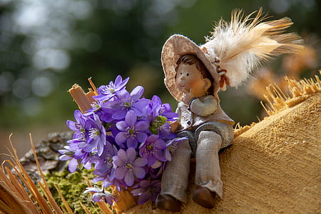 photo of purple flowers beside gray doll during daytime thumbnail