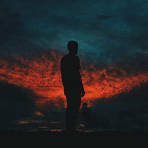 silhouette of person standing under red sky thumbnail