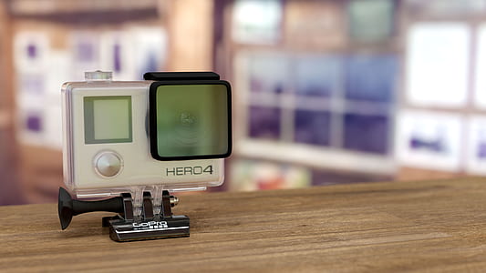 silver GoPro HERO4 on brown wooden surface thumbnail