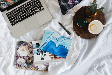 Bed full of pillows and notebooks with Apple gadgets thumbnail