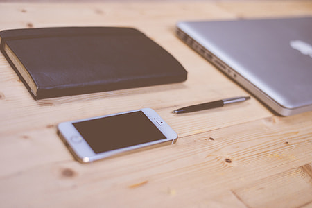 iPhone and MacBook on Wooden Desk thumbnail