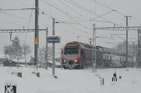 red and black train beside snowfield thumbnail
