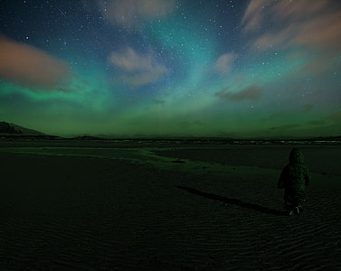 person walking under northern lights thumbnail